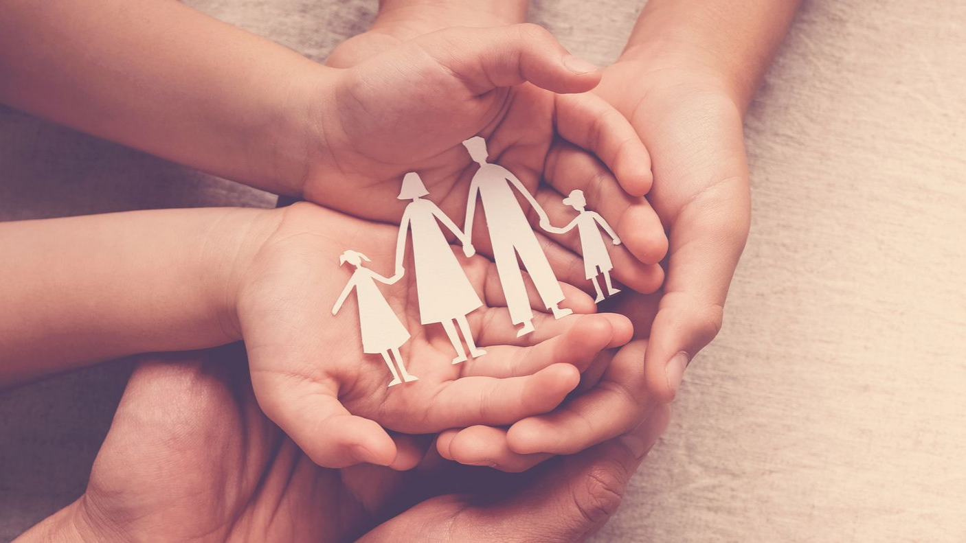 Silhouettes d'une famille en papier dans les mains d'une famille