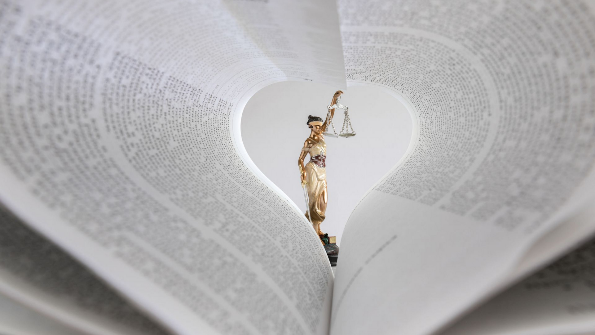 Statue de la femme de la justice dans un cœur fait de pages d'un livre