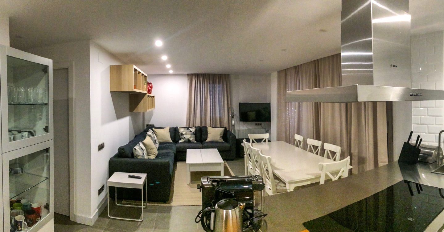 Una sala de estar con sofá, mesa y sillas.