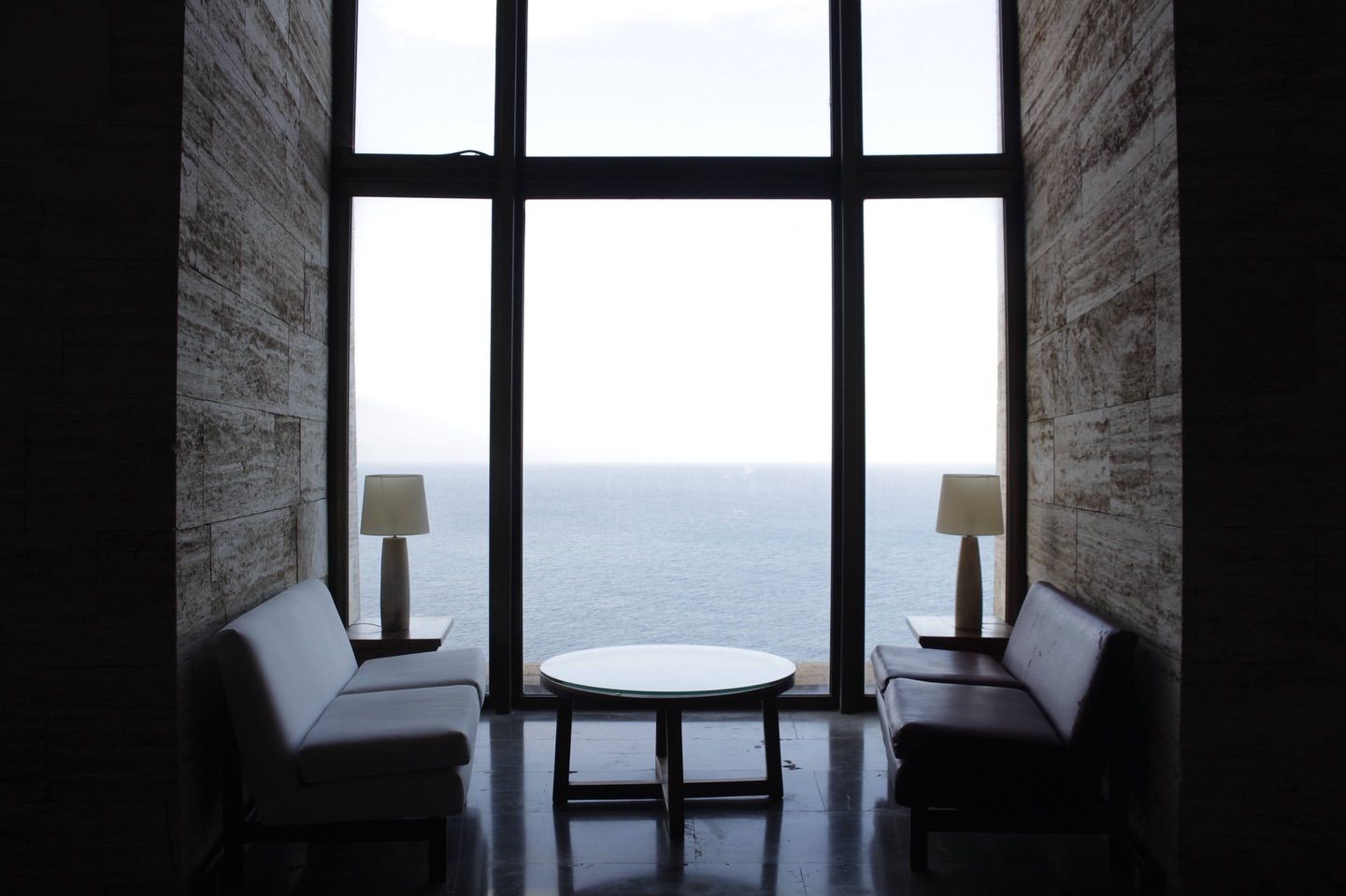 Una sala de estar con un gran ventanal con vista al mar.