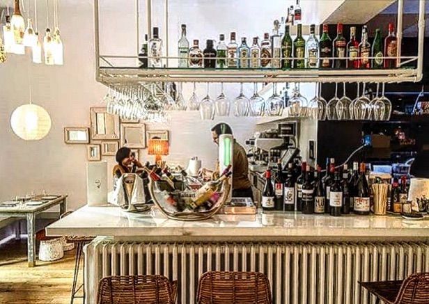 Un bar con muchas botellas y vasos encima.