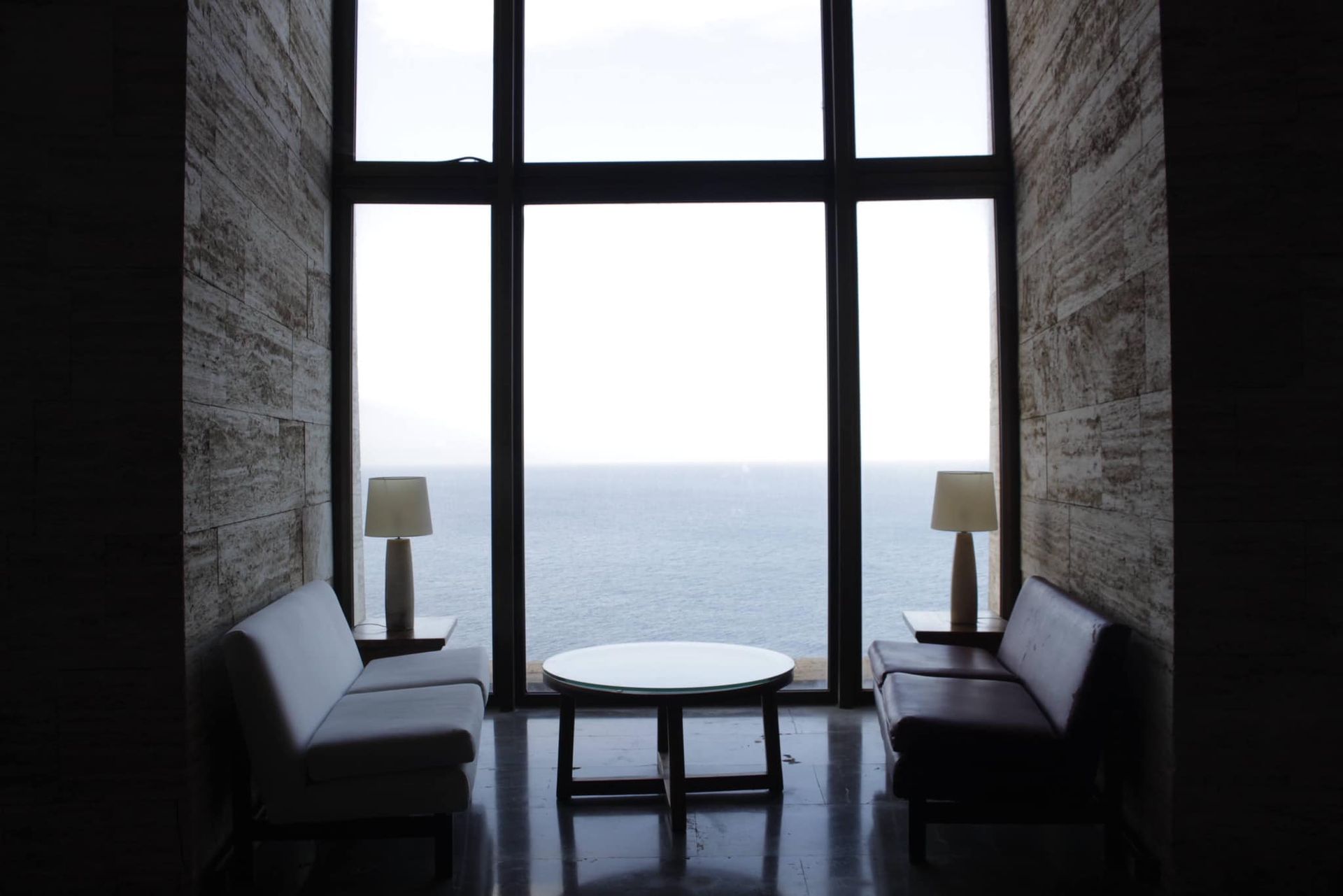 Una sala de estar con un gran ventanal con vista al mar.