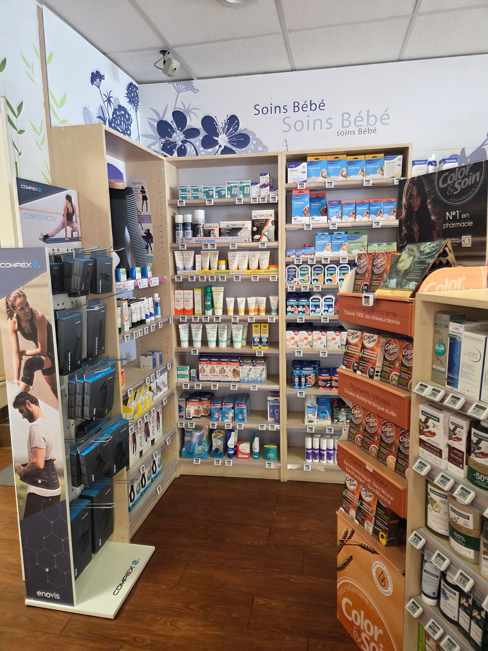 Produits pour bébés présentés dans une petite allée de pharmacie