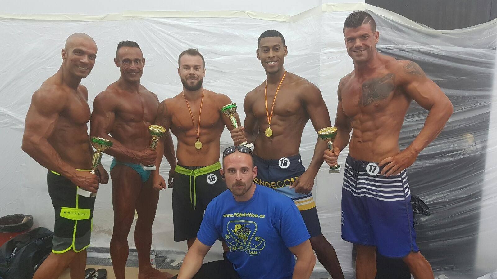 Un grupo de hombres de pie uno al lado del otro sosteniendo trofeos.