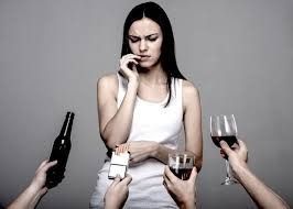 Una mujer está rodeada de gente que sostiene botellas de vino, cigarrillos y copas de vino.