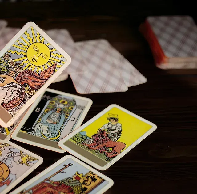 Varias cartas del tarot sobre una mesa, incluido el sol.