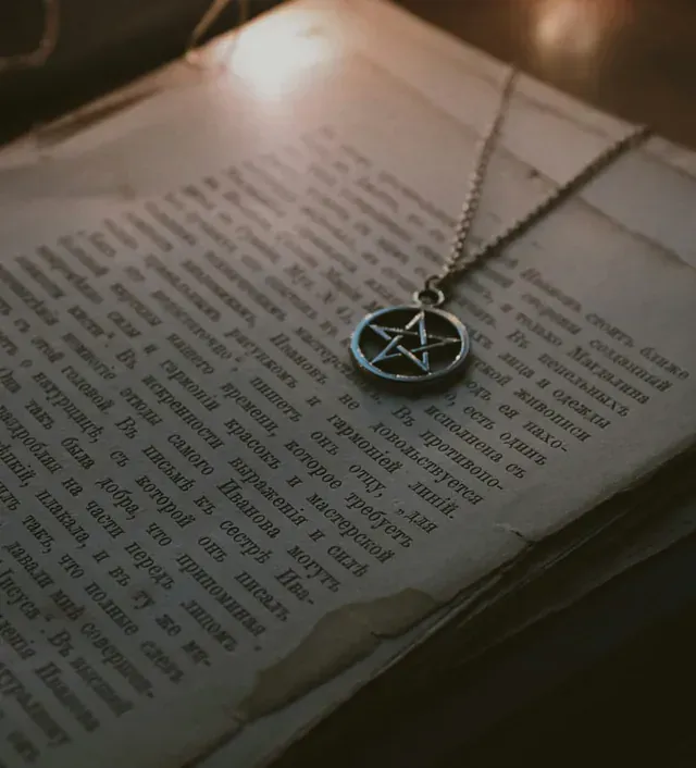 Un collar de pentagrama está encima de un libro.