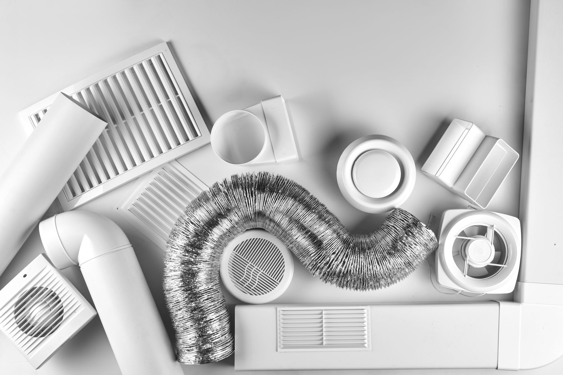 Vue de dessus d'objets en papier blanc et de bandes enroulées disposées selon un motif abstrait.
