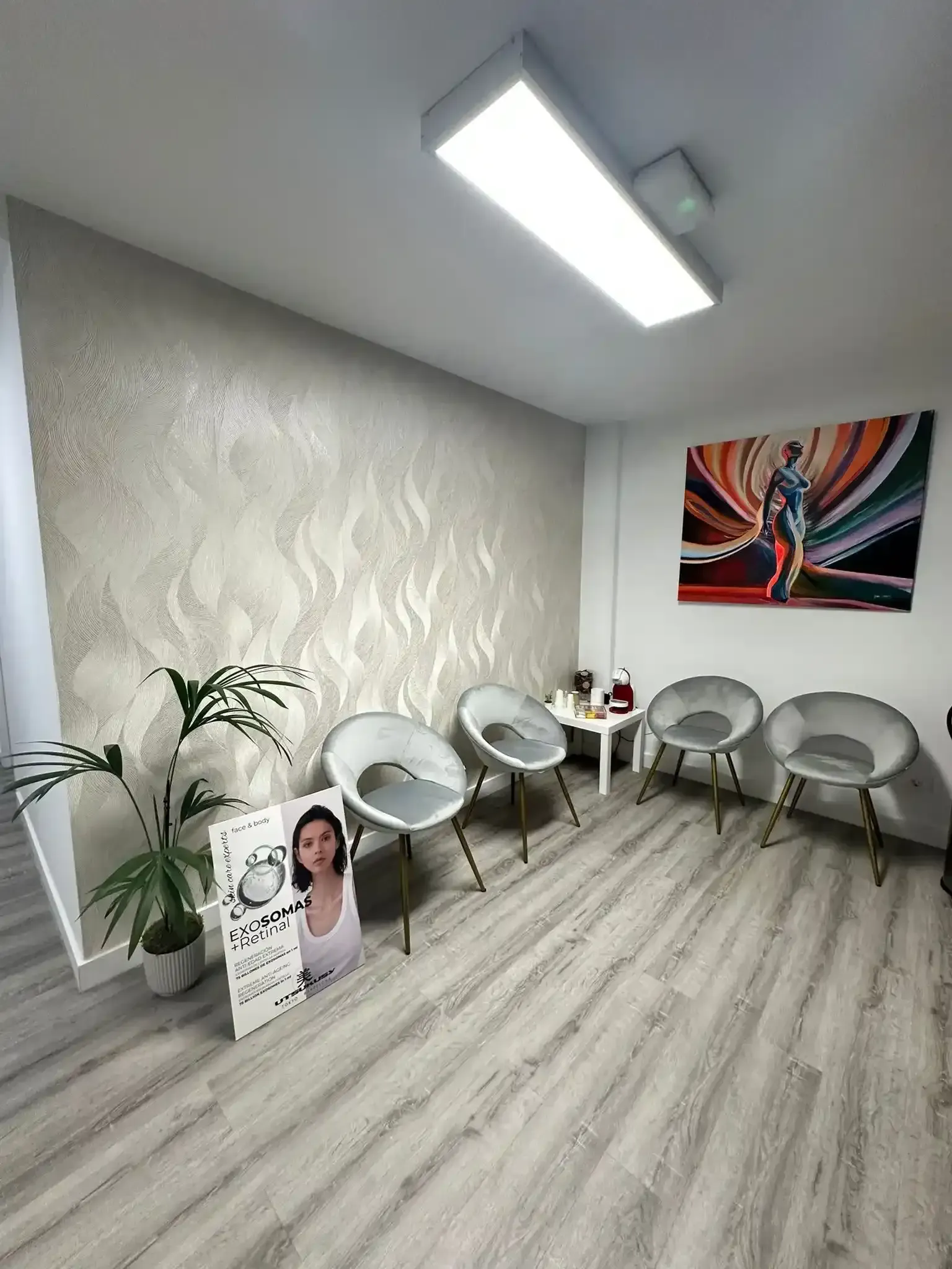 Área de recepción para Sapphira Prive, con logo negro y dorado, mostrador blanco y gris y vitrina.