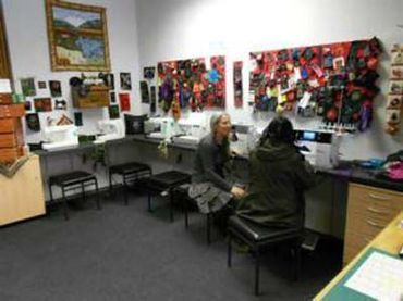 Zwei Frauen sitzen an einem Tisch in einem Raum mit einer Nähmaschine