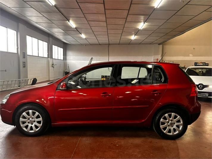 Volkswagen Golf rojo aparcado dentro de un garaje.