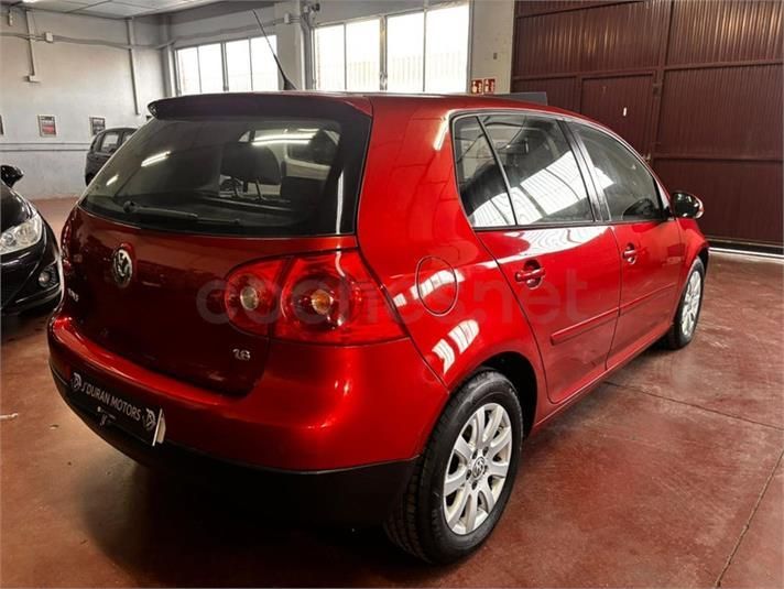 Volkswagen Golf hatchback de color rojo en un garaje.