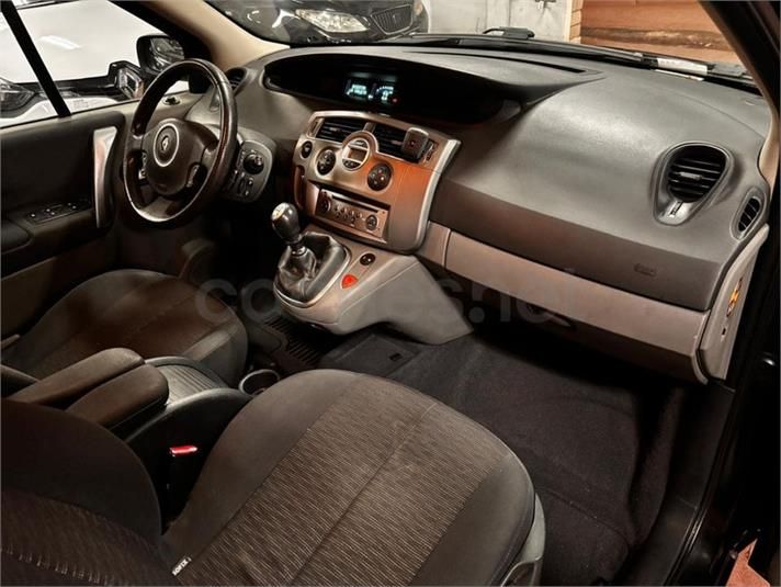 Vista interior de un tablero de instrumentos, volante, asientos y consola de un Renault de color gris.