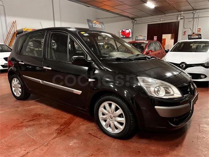 Renault Scenic negro aparcado dentro de un garaje, junto a otros vehículos.