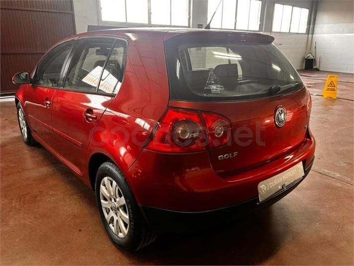 Volkswagen Golf rojo estacionado dentro de un garaje, vista trasera.