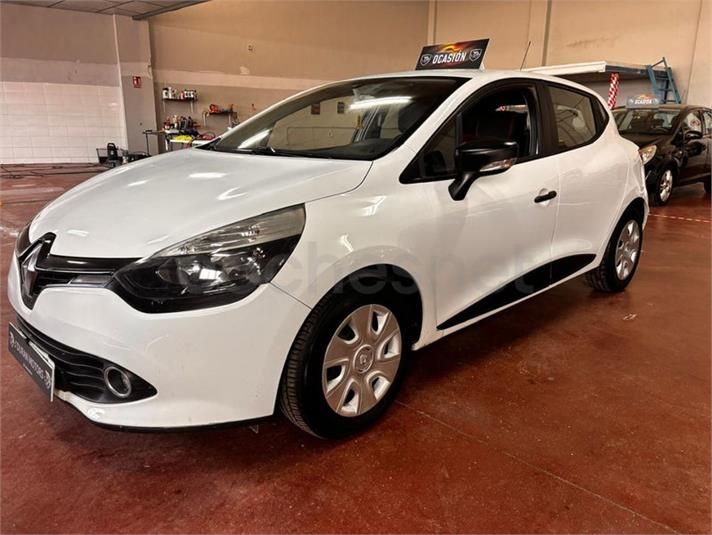 Renault Clio blanco aparcado en el interior de un garaje con suelo rojo.