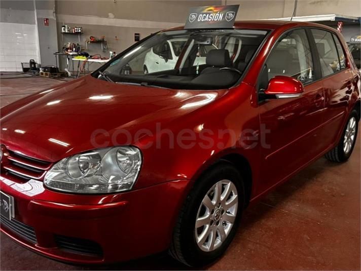 Coche Volkswagen Golf rojo en un garaje con cartel de