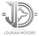 Logotipo plateado con iniciales "JD" y cabeza de lobo, "J. Duran Motors" debajo.