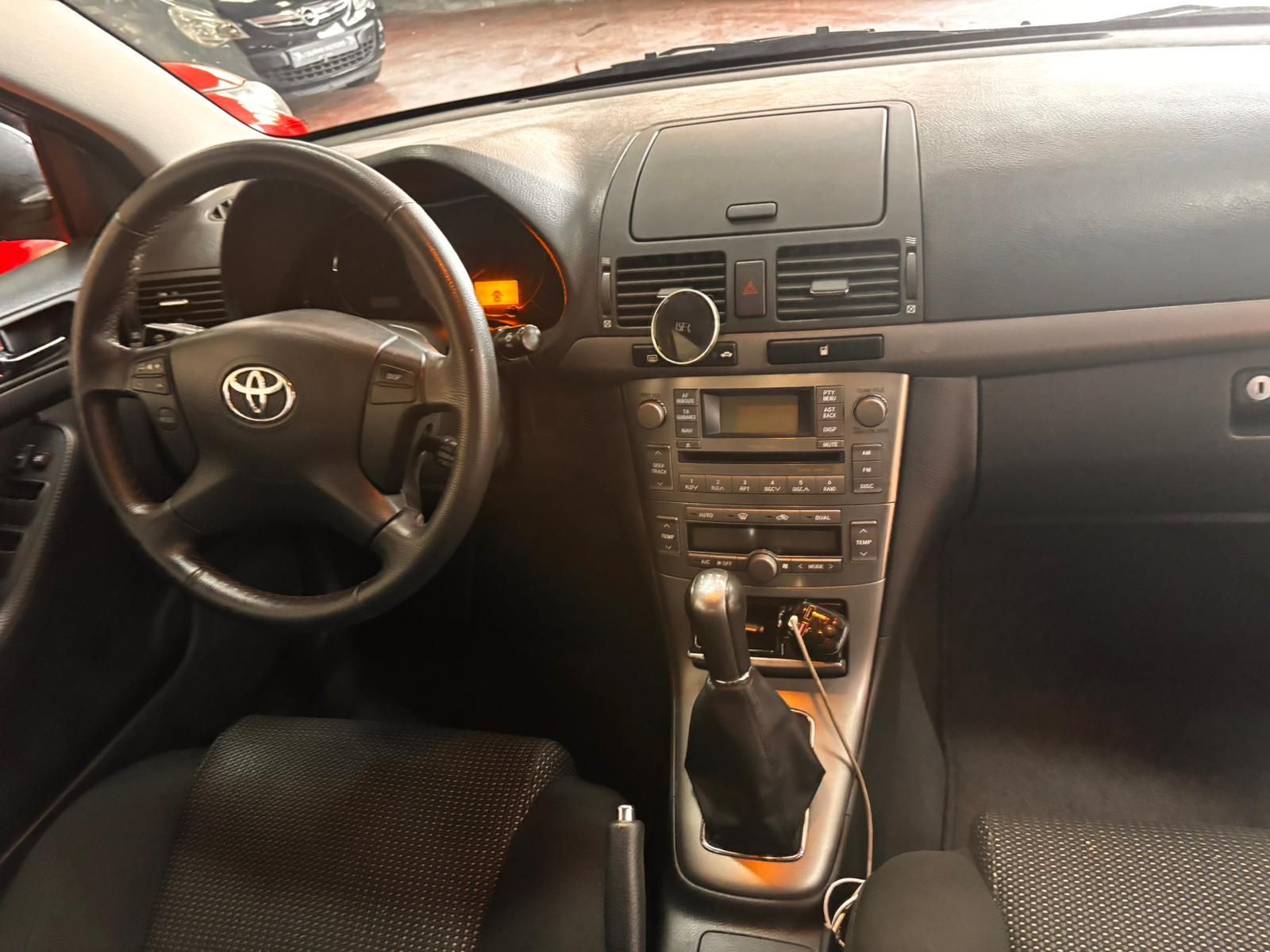 El interior del habitáculo de un coche Toyota, donde se aprecian el volante, el salpicadero, la consola central y la palanca de cambios.