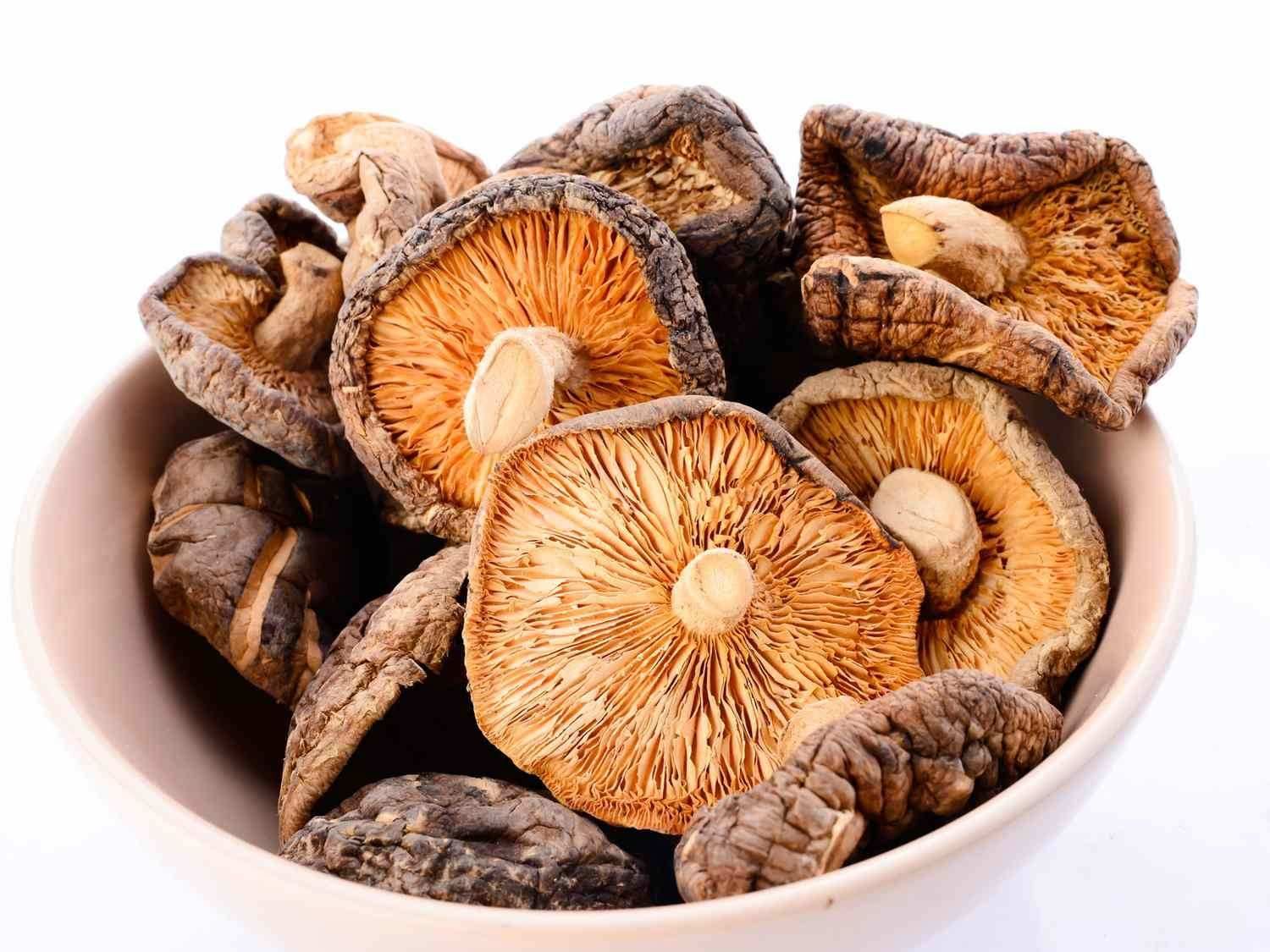 Un cuenco blanco lleno de setas shiitake 