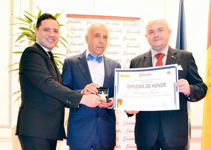 Tres hombres con traje y corbata están de pie uno al lado del otro sosteniendo un diploma.