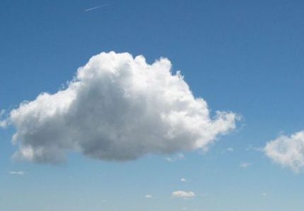 Una gran nube blanca flota en un cielo azul.