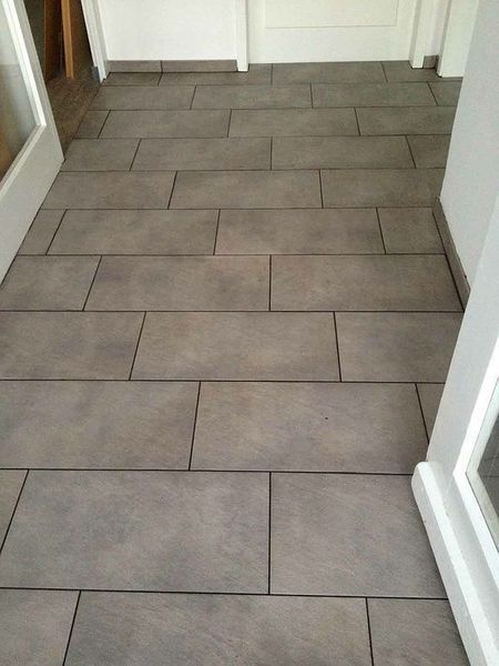 Ein Flur mit gefliestem Boden und einer weißen Tür