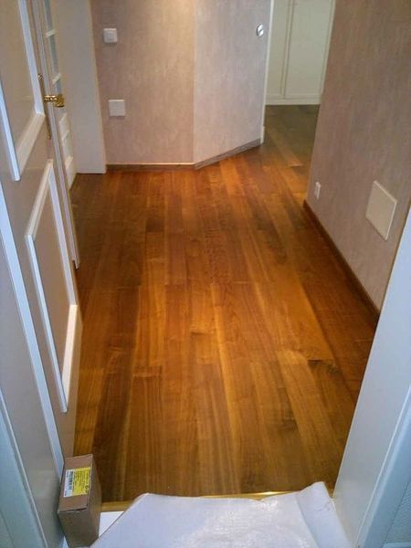 Ein Flur mit Holzboden und einer Kiste auf dem Boden.