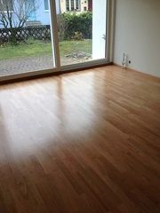 Ein Wohnzimmer mit Holzboden und Glasschiebetür.