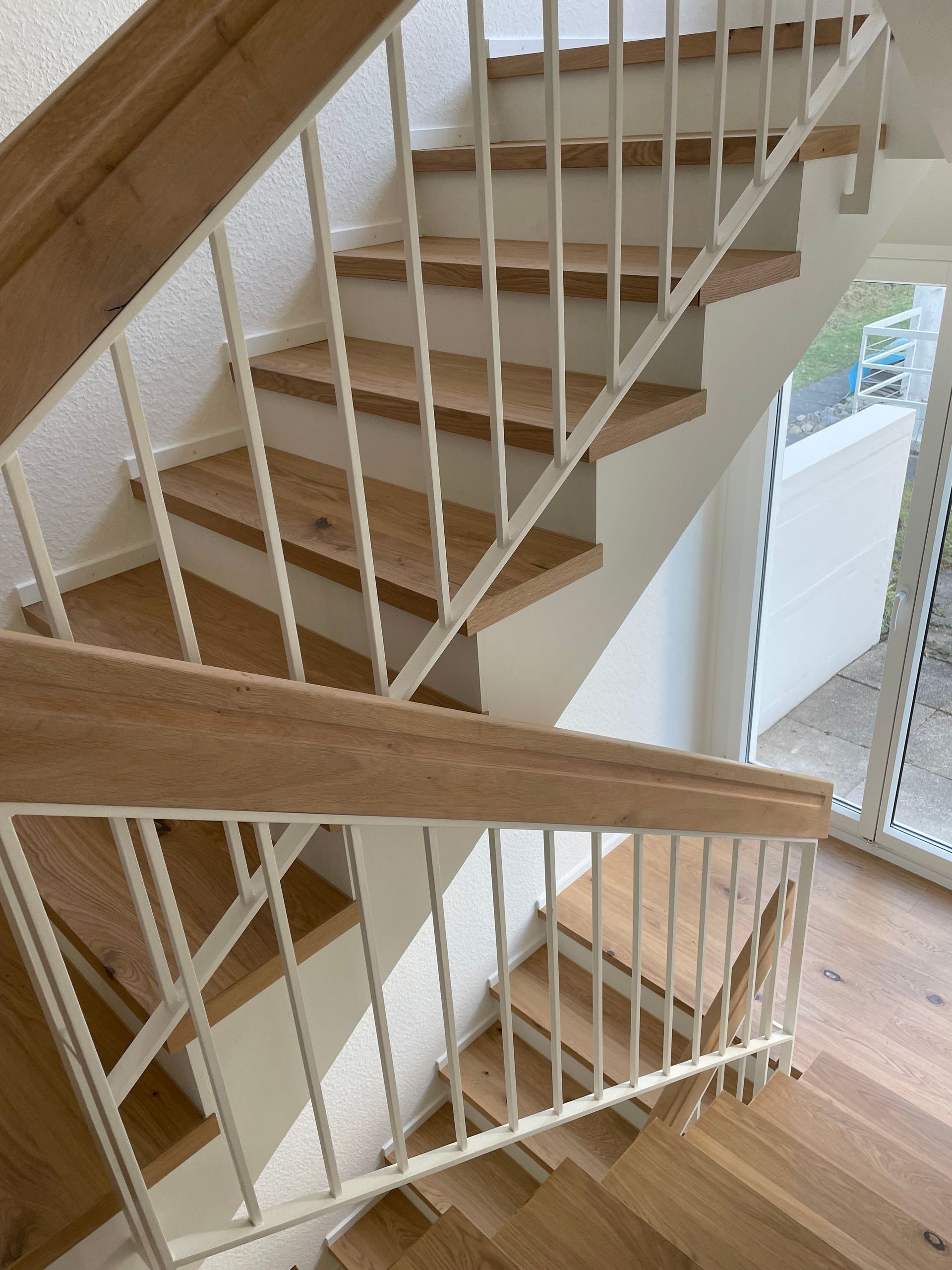 Eine Treppe mit Holzstufen und einem weißen Geländer