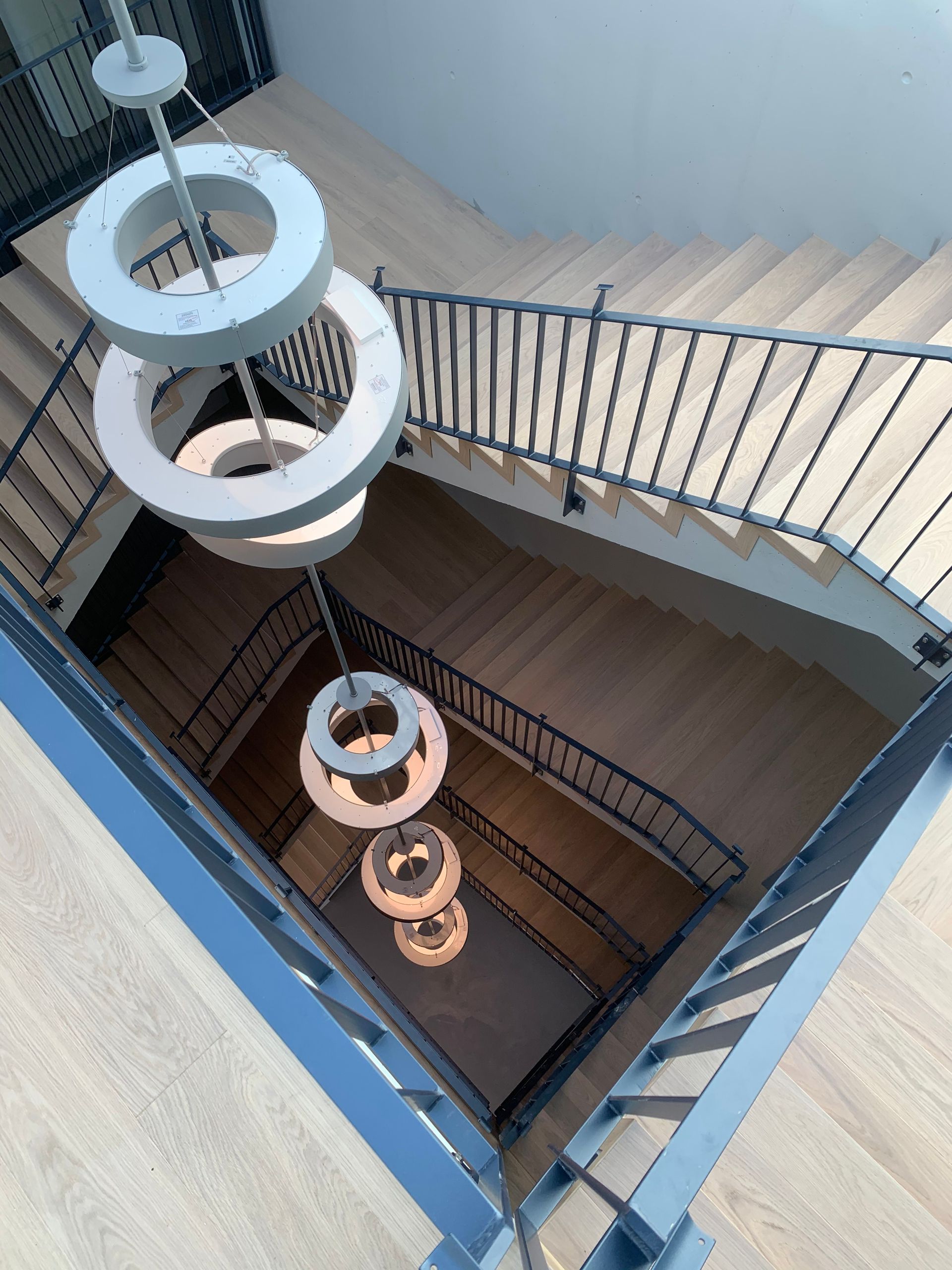 Eine Luftaufnahme einer Treppe mit einem Kronleuchter, der von der Decke hängt.