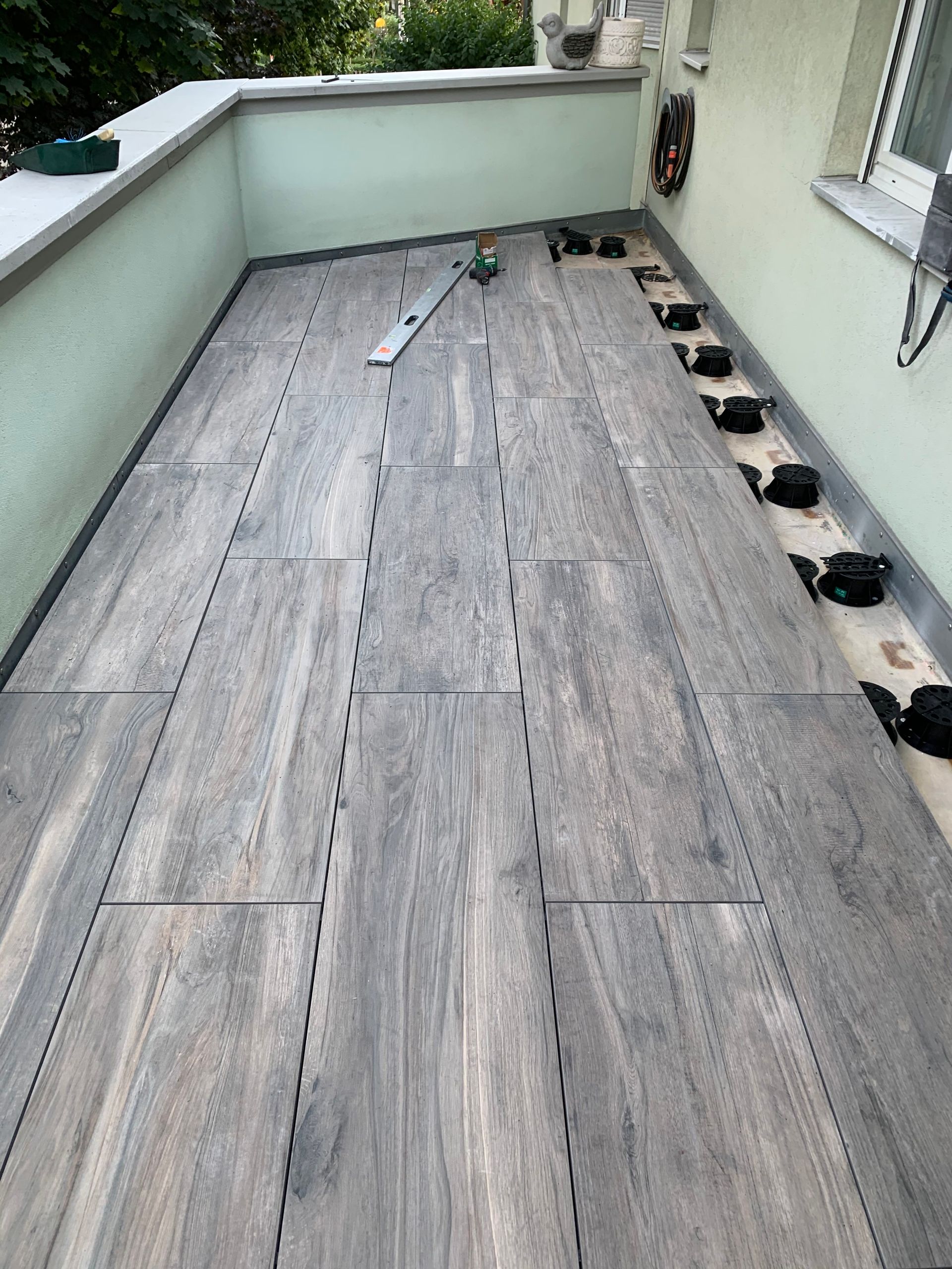 Auf einem Balkon wird ein Holzboden verlegt.