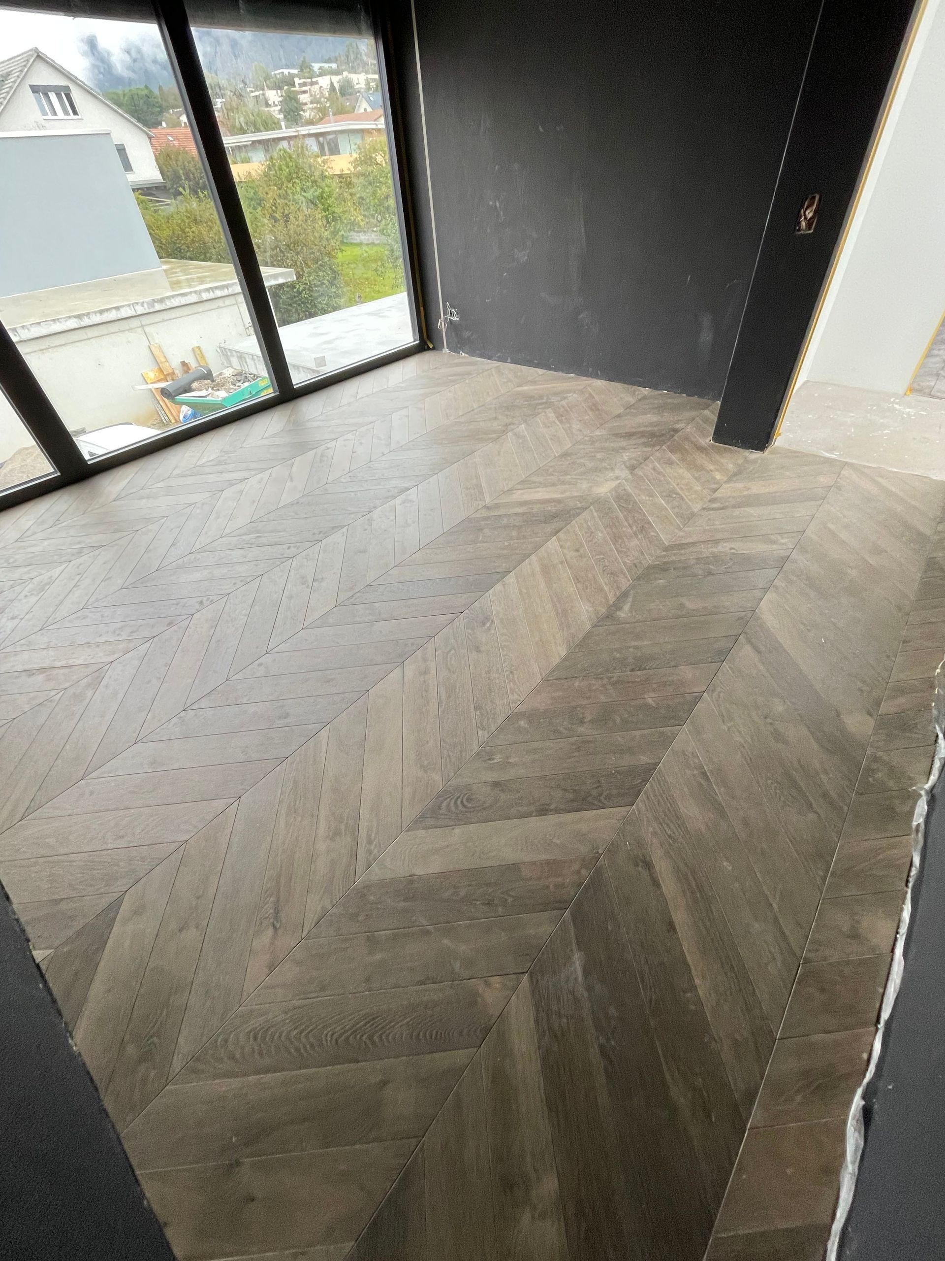 Ein Raum mit Holzboden und großem Fenster.