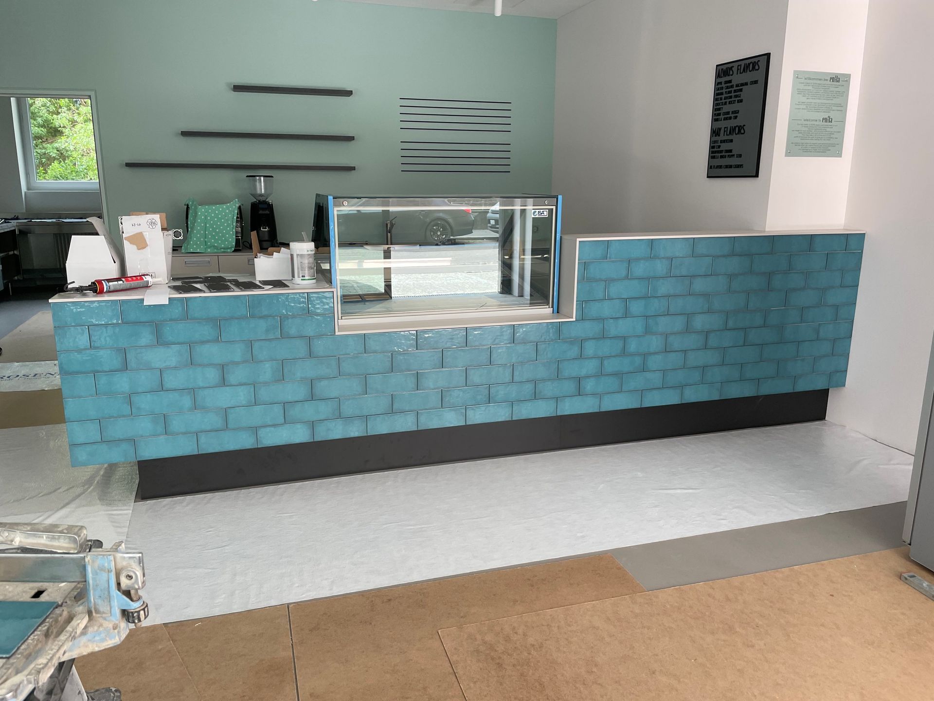 Eine blaue Backsteintheke mit einer Glasvitrine in einem Raum.