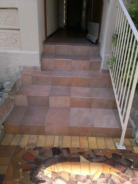 Eine Treppe führt zu einer Tür mit einem weißen Geländer.