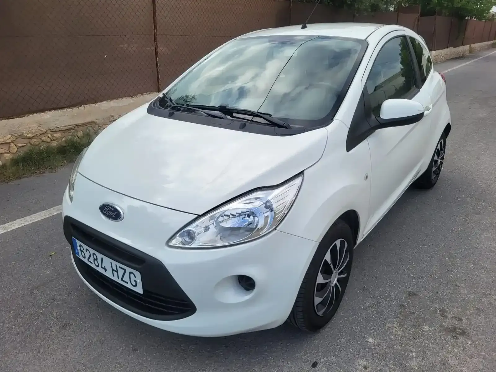 Ford Ka blanco estacionado en una calle.