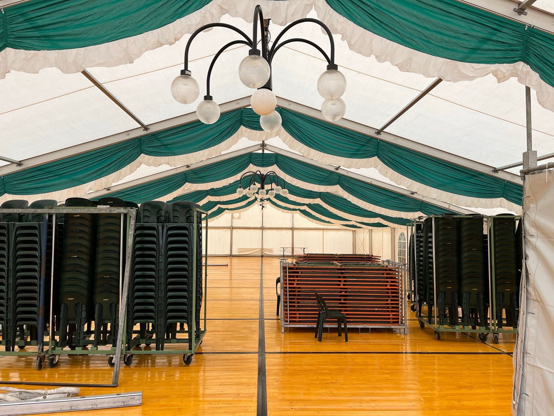 Eine Reihe von Stühlen ist unter einem Zelt aufgereiht