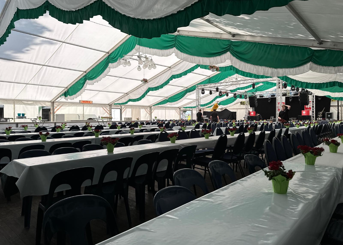 Ein großer Raum mit Tischen und Stühlen unter einem Zelt
