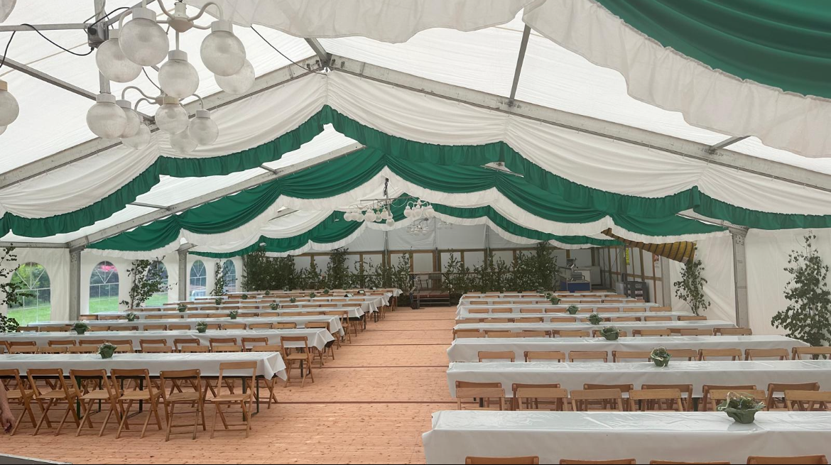 Ein großes Zelt mit Tischen und Stühlen darunter