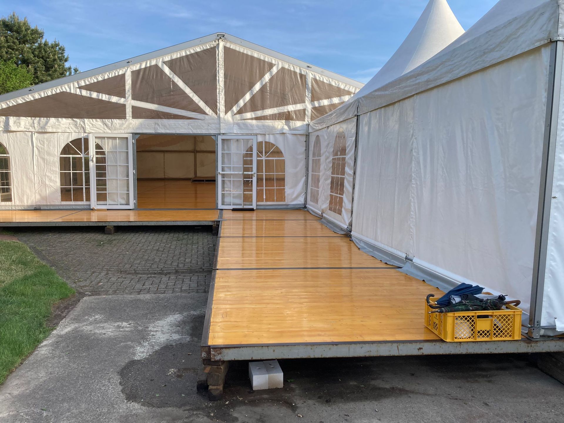 Ein großes weißes Zelt mit einem Holzboden davor