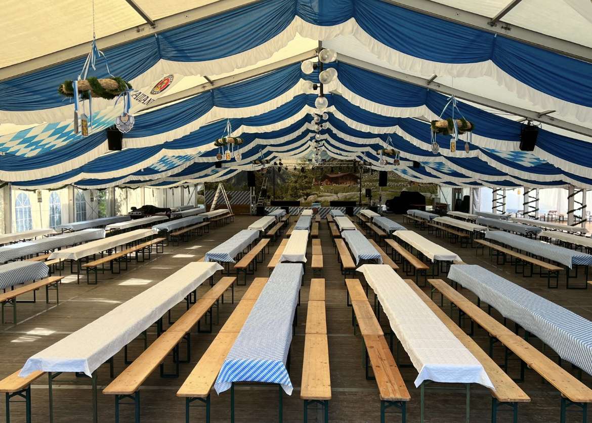 Ein großes Zelt mit Tischen und Bänken darunter