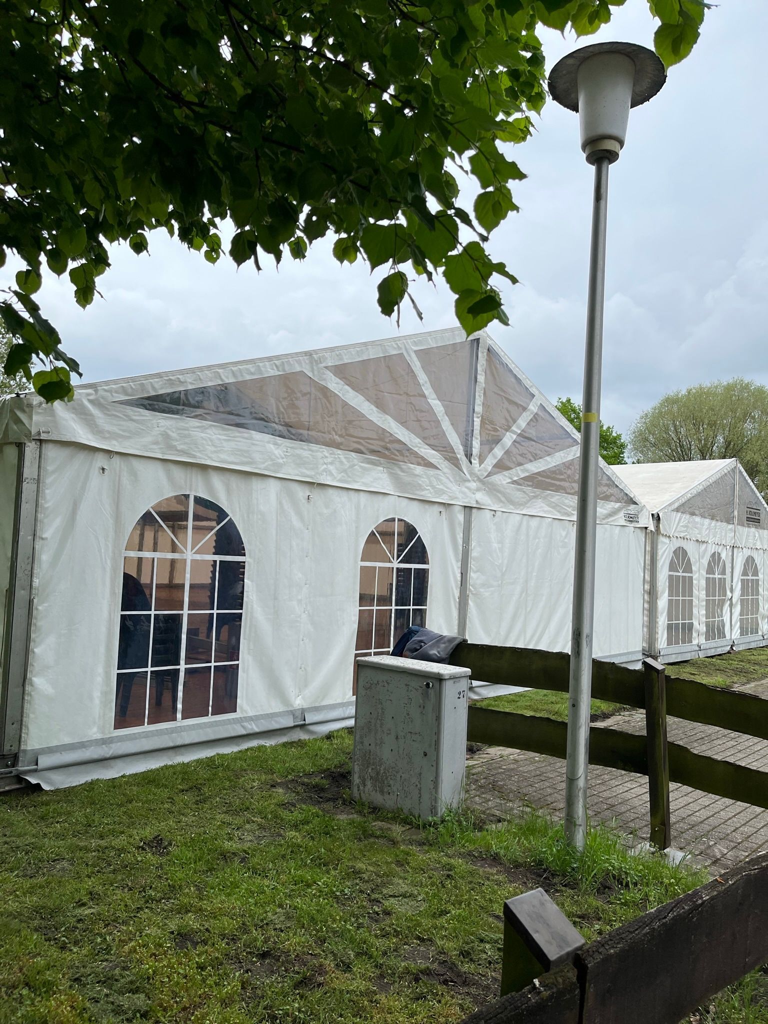 Ein großes weißes Zelt steht inmitten einer Wiese.