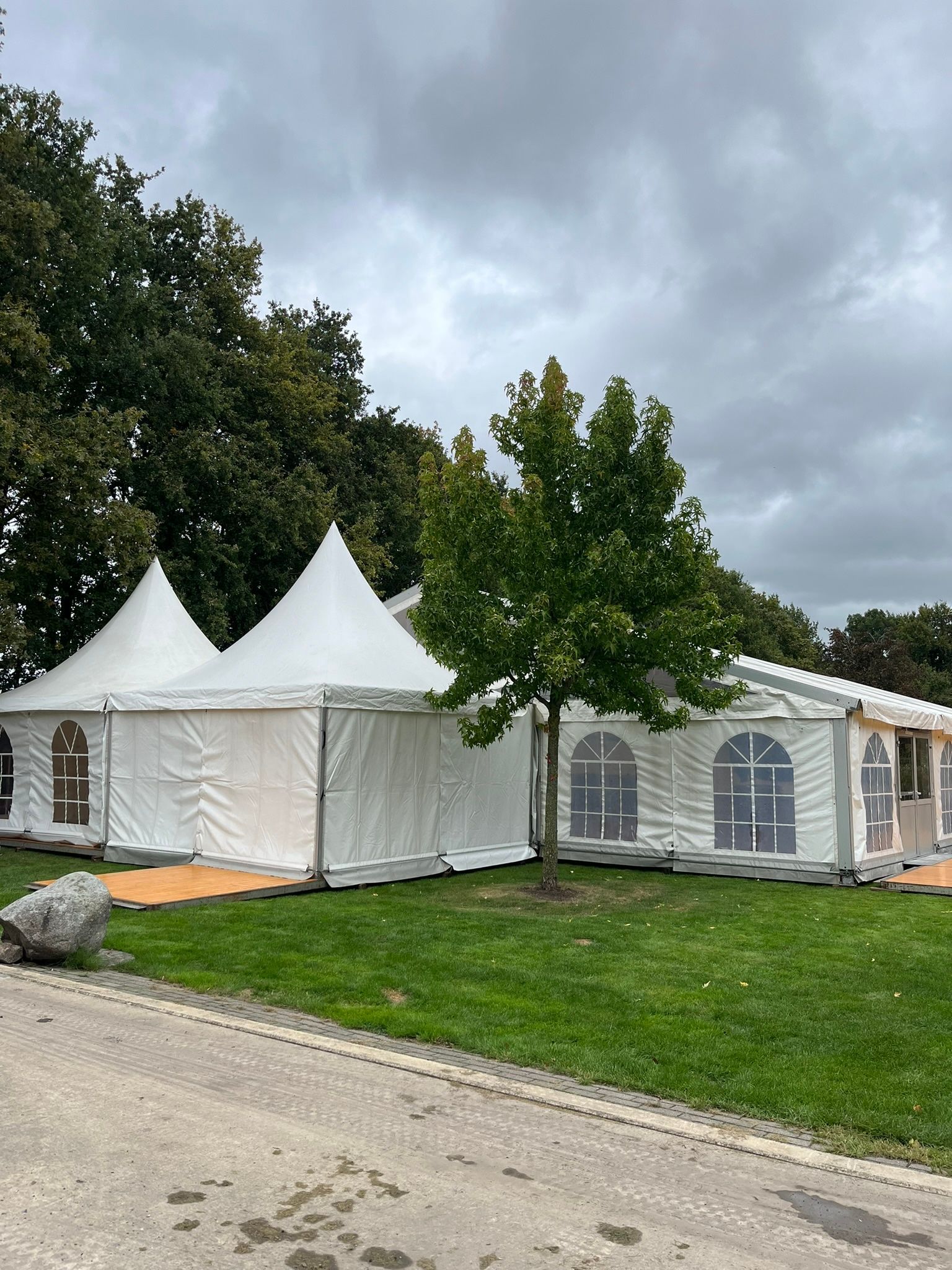 Ein großes weißes Zelt steht inmitten einer üppigen grünen Wiese.