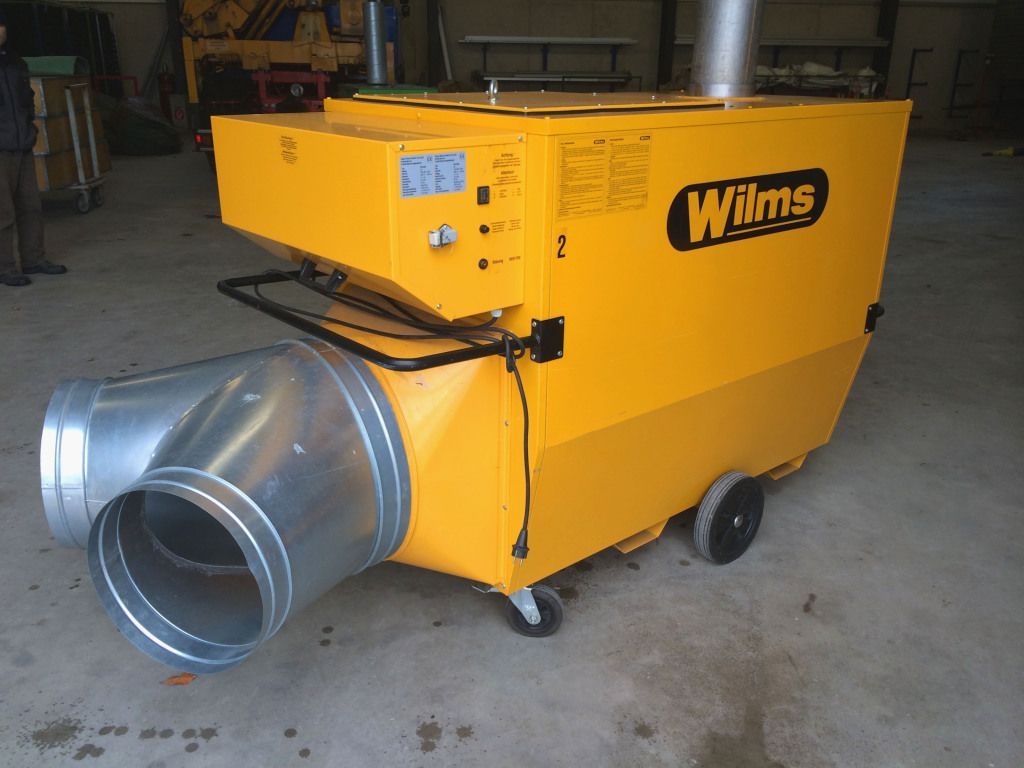 Eine gelbe Wilms-Maschine steht in einer Garage