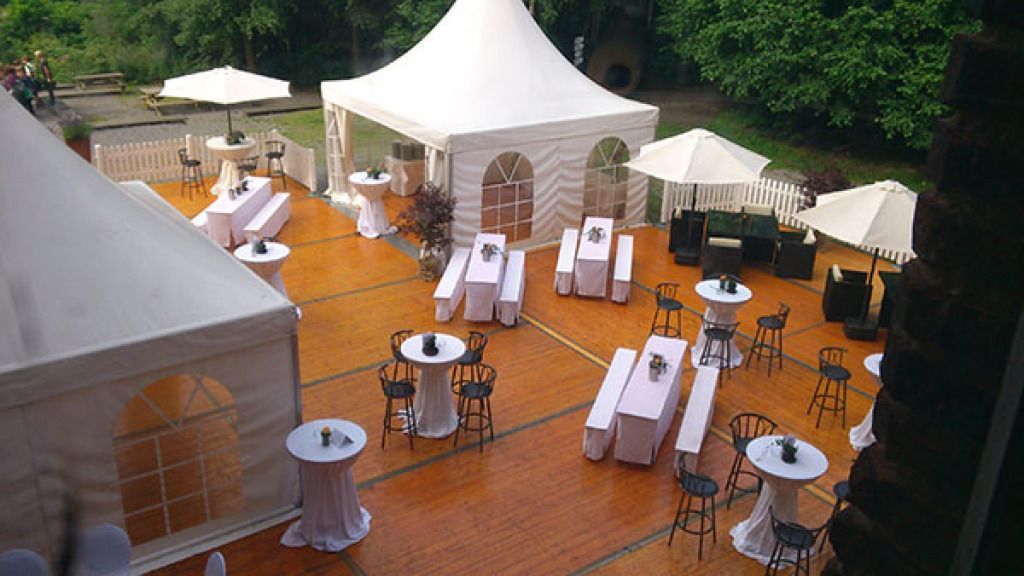 Eine Luftaufnahme eines Zelts mit Tischen und Stühlen, das für eine Party aufgestellt ist.