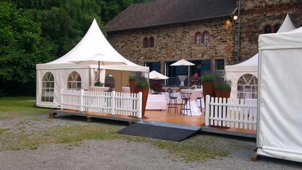 Ein großes Steingebäude mit vielen Zelten davor