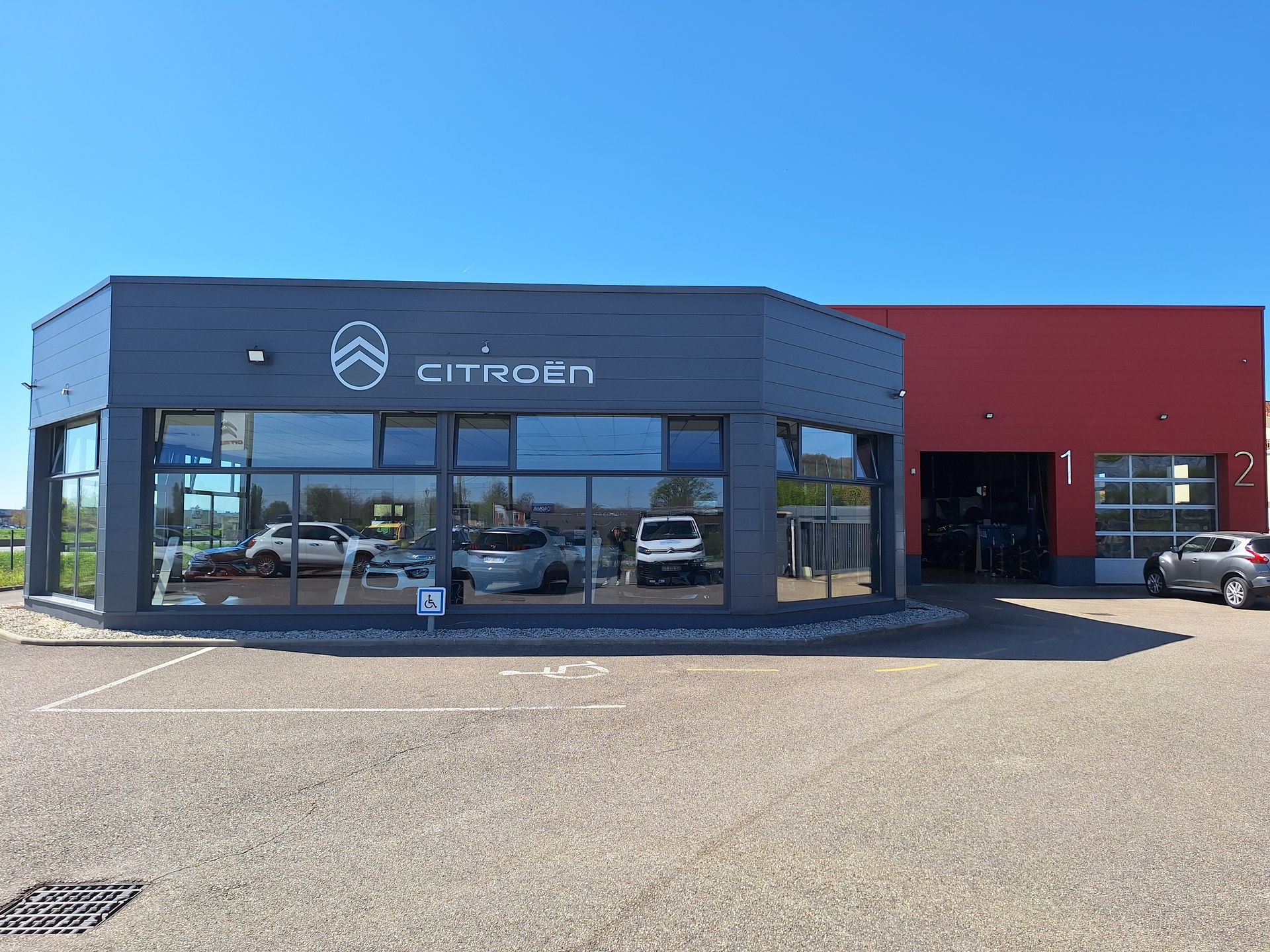 Façade de concession Citroën noire et rouge par temps ensoleillé