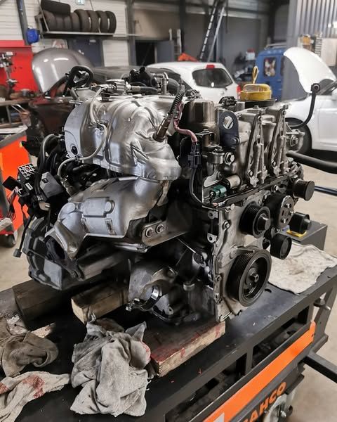 Moteur automobile démonté visible sur un établi d'atelier