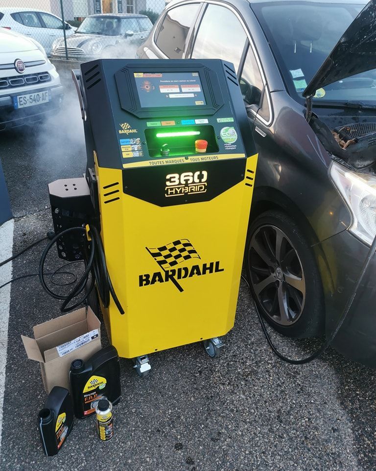 Machine Bardahl jaune pour entretien automobile utilisée à côté d'un véhicule
