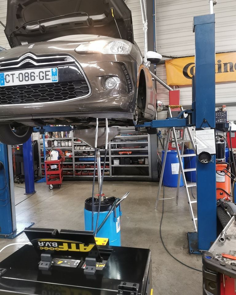 Atelier de mécanique avec voiture sur pont élévateur et outils à disposition